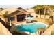 Backyard featuring a refreshing swimming pool, a covered patio with lounge seating, and mature palm trees at 203 W Raven Dr, Chandler, AZ 85286