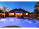 Backyard pool at twilight reflects the home's windows, with lounge chairs and desert landscaping at 203 W Raven Dr, Chandler, AZ 85286