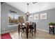 Charming dining area with stylish light fixture, views of the pool, and wood-look tile flooring at 203 W Raven Dr, Chandler, AZ 85286