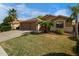 Attractive home with a well-kept lawn, mature trees, and a spacious driveway leading to a two-car garage at 203 W Raven Dr, Chandler, AZ 85286