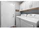 Laundry room with upper cabinets over the side-by-side washer and dryer, and a door to the outside at 203 W Raven Dr, Chandler, AZ 85286