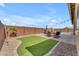 Lush backyard with an artificial grass area, a dining set, and a sparkling pool nearby at 20340 E Camacho Rd, Queen Creek, AZ 85142