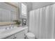 Bright bathroom featuring tiled shower, decorative mirror, white vanity, and plantation shutters at 20340 E Camacho Rd, Queen Creek, AZ 85142