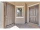 Covered entrance with neutral-toned doors, a small window, and a brick-paved porch at 20340 E Camacho Rd, Queen Creek, AZ 85142