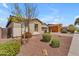 Landscaped front yard with desert landscaping, a young tree, and a view of neighboring homes at 20340 E Camacho Rd, Queen Creek, AZ 85142
