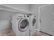 Bright laundry room with a front loading washing machine, dryer, shelving, and tile floors at 20340 E Camacho Rd, Queen Creek, AZ 85142