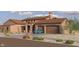 Expansive stone-accented home featuring a front-facing two-car garage and a light blue vehicle parked in the driveway at 21235Xxx W Elliot Rd, Buckeye, AZ 85326