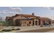Side view of the stone-accented home featuring a front-facing two-car garage and a light blue vehicle parked in the driveway at 21235Xxx W Elliot Rd, Buckeye, AZ 85326