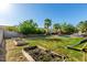 Expansive backyard featuring a pool, tropical palm trees, string lights, and garden beds at 21266 S 213Th Pl, Queen Creek, AZ 85142