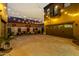 Spacious backyard with ambient string lights, bench seating, planters, and an attached two-car garage at 21266 S 213Th Pl, Queen Creek, AZ 85142