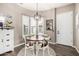 Cozy dining room featuring a round table, modern light fixture, wood floors, and bright natural light at 21266 S 213Th Pl, Queen Creek, AZ 85142