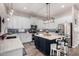 Spacious kitchen with an island, white cabinets, stainless steel appliances, and stylish light fixtures at 21266 S 213Th Pl, Queen Creek, AZ 85142