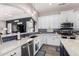 Stylish kitchen showcasing white cabinetry, a dark blue backsplash, and modern stainless steel appliances at 21266 S 213Th Pl, Queen Creek, AZ 85142