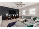 Spacious living room features a large sectional sofa, media center, and modern ceiling fan at 21266 S 213Th Pl, Queen Creek, AZ 85142