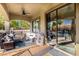 Covered patio featuring comfortable seating, ceiling fan, and sliding glass doors to the interior at 21266 S 213Th Pl, Queen Creek, AZ 85142