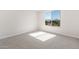 Sunlit bedroom featuring carpeted floors and a large window with neighborhood views at 21296 N 270Th Dr, Buckeye, AZ 85396