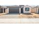 Charming single-story home with a well-manicured lawn and a two-car garage with brick paved driveway at 21296 N 270Th Dr, Buckeye, AZ 85396