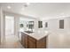 Open-concept kitchen features an island with sink, white countertops, and view of the living space at 21296 N 270Th Dr, Buckeye, AZ 85396