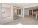 Spacious living area with sliding glass doors and tiled floors leading to kitchen at 21296 N 270Th Dr, Buckeye, AZ 85396