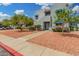 Attractive condominium complex with mature landscaping, vibrant flowers and a sidewalk leading to the building's entrance at 220 N 22Nd Pl # 2041, Mesa, AZ 85213