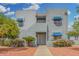 Charming two-story condo featuring blue window awnings and desert landscaping with palm trees and flowering bushes at 220 N 22Nd Pl # 2041, Mesa, AZ 85213