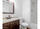 Bathroom with dark wood vanity, marble countertop, toilet, and shower with white tile at 2262 E Javelina Ave, Mesa, AZ 85204