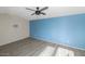 Bedroom with light laminate floors, a blue accent wall, and a ceiling fan at 2262 E Javelina Ave, Mesa, AZ 85204