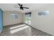 Bright bedroom features vinyl flooring, a ceiling fan, and double doors leading to the backyard at 2262 E Javelina Ave, Mesa, AZ 85204