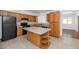 Functional kitchen with island, wooden cabinets, and black appliances at 2262 E Javelina Ave, Mesa, AZ 85204