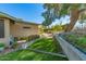 Landscaped backyard with lush greenery, garden beds, and a charming walkway at 2433 E Acoma Dr, Phoenix, AZ 85032
