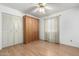 A bedroom with wood floors, a ceiling fan, standard closet, and a murphy bed at 2433 E Acoma Dr, Phoenix, AZ 85032