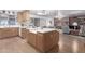 Spacious kitchen open to the living area, featuring an island with light countertops and wood floors at 2433 E Acoma Dr, Phoenix, AZ 85032