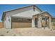 Home featuring a large brown garage door, brick driveway, and stylish architectural details for enhanced curb appeal at 25188 N 174Th Ave, Surprise, AZ 85387