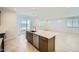 Open kitchen layout with a spacious island, stainless steel dishwasher, tile floors, and access to the patio through sliding glass doors at 25188 N 174Th Ave, Surprise, AZ 85387