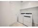Bright laundry room with modern washer and dryer, plus a shelf at 25188 N 174Th Ave, Surprise, AZ 85387