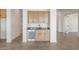 A cozy wet bar area with wooden cabinets, stainless steel mini-fridge, and stylish tiling at 27046 W Rockwood Dr, Buckeye, AZ 85396