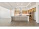 Modern kitchen features a large island, light wood cabinets, stainless steel appliances, and stone countertops at 27046 W Rockwood Dr, Buckeye, AZ 85396