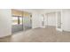 Bright living room with tiled floor, large sliding glass door and open French doors at 27046 W Rockwood Dr, Buckeye, AZ 85396