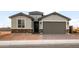 Inviting single-Gathering home showcases stone accents and a covered entryway leading to a spacious two-car garage at 27110 W Adam Ave, Buckeye, AZ 85396