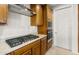Close up of a modern kitchen cooktop, stainless vent hood, and built-in appliances at 27110 W Adam Ave, Buckeye, AZ 85396