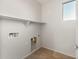 A functional laundry room with tile flooring, ample shelving, and convenient utility connections at 27110 W Adam Ave, Buckeye, AZ 85396