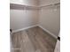 Walk-in closet with basic shelving offers ample storage space and wood-look floors at 2729 E Carol Ave, Mesa, AZ 85204