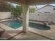 A private backyard pool, surrounded by a desert landscape and block fence at 2729 E Carol Ave, Mesa, AZ 85204