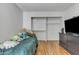 Bright bedroom with wood floor, closet, TV, and twin bed with cute stuffed animals at 2834 S Extension Rd # 1079, Mesa, AZ 85210