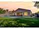 Backyard featuring lush artificial turf, a putting green, a seating area, and ambient string lights at 3662 E Megan St, Gilbert, AZ 85295