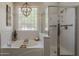 Bright bathroom featuring a separate soaking tub and shower with glass enclosure and transom window at 3662 E Megan St, Gilbert, AZ 85295