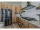 Modern kitchen with stainless steel appliances, including a refrigerator, and light wood cabinets at 3662 E Megan St, Gilbert, AZ 85295
