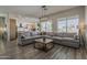 Spacious living room featuring a large sectional sofa, wood floors, and modern lighting at 3662 E Megan St, Gilbert, AZ 85295