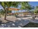 Well-maintained community playground with a covered play structure, bench seating, and paved walking paths at 3662 E Megan St, Gilbert, AZ 85295