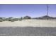 Wide angle shot of backyard with gravel landscape with single story home in the background under a clear blue sky at 3725 N Bandelier Dr, Eloy, AZ 85131